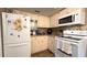 Efficient kitchen with white appliances, wood-look flooring, and mosaic tile backsplash at 9430 Sw 102Nd Pl, Ocala, FL 34481