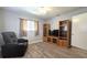 Bright living room features wood-look floors, modern grey walls, and custom entertainment center at 9430 Sw 102Nd Pl, Ocala, FL 34481