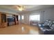 Cozy living room with comfortable seating, a large window with curtains, and a ceiling fan, hardwood floors at 9430 Sw 102Nd Pl, Ocala, FL 34481