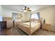 Comfortable main bedroom with wood-look flooring, ceiling fan, and matching wooden furniture at 9430 Sw 102Nd Pl, Ocala, FL 34481