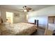 Large main bedroom with wood-look flooring, ceiling fan, and entrance to the en suite bathroom at 9430 Sw 102Nd Pl, Ocala, FL 34481