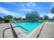 Large community pool with clear blue water surrounded by mature trees and lounge chairs at 9430 Sw 102Nd Pl, Ocala, FL 34481