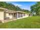 Spacious backyard with a well-maintained lawn, mature trees, and an enclosed patio at 9667 Sw 94Th Ct # C, Ocala, FL 34481