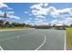 Community outdoor basketball court with well-maintained playing surface and covered picnic areas under a cloudy blue sky at 9667 Sw 94Th Ct # C, Ocala, FL 34481