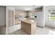 Kitchen featuring light wood cabinets, white appliances, tile floor, and a center island at 9667 Sw 94Th Ct # C, Ocala, FL 34481