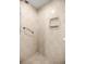 Close-up of the shower featuring tiled walls, a built-in niche, and a grab bar for safety at 9667 Sw 94Th Ct # C, Ocala, FL 34481