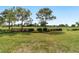Expansive backyard with lush green lawn, mature trees, and picturesque golf course view at 9839 Sw 90Th St, Ocala, FL 34481