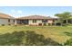 Back exterior view featuring a screened-in patio and manicured backyard with tidy landscaping at 9839 Sw 90Th St, Ocala, FL 34481