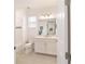 Bright bathroom with white cabinets, tile floors, and a large mirror at 9839 Sw 90Th St, Ocala, FL 34481