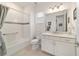 Bright bathroom with white cabinets, tile floors, and a large mirror at 9839 Sw 90Th St, Ocala, FL 34481