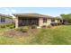 Exterior view of the home showcasing the screened patio and well-manicured backyard at 9839 Sw 90Th St, Ocala, FL 34481