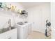 Functional laundry room with washer, dryer, sink, and shelving at 9839 Sw 90Th St, Ocala, FL 34481