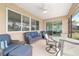 Inviting covered patio with comfortable seating, a ceiling fan, and access to the home's interior at 9839 Sw 90Th St, Ocala, FL 34481