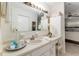 Bathroom featuring a large vanity, bright lighting, modern faucet, and an adjacent bedroom with ceiling fan at 9940 Sw 101St Pl, Ocala, FL 34481