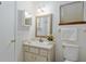 Well-lit bathroom with a decorative mirror, white fixtures, and a convenient vanity at 9940 Sw 101St Pl, Ocala, FL 34481