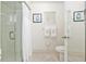 Bathroom with tiled floors, a glass-enclosed shower, decorative wall art, and neatly arranged towels at 9940 Sw 101St Pl, Ocala, FL 34481