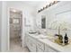 Bathroom with an extended vanity, modern lighting, and a decorated countertop, leading into a toilet and shower area at 9940 Sw 101St Pl, Ocala, FL 34481
