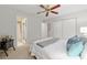 Bedroom with carpeted floor, ceiling fan, view into bathroom, closet, and a bed with blue and gray accents at 9940 Sw 101St Pl, Ocala, FL 34481