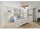 Bedroom featuring a ceiling fan, carpeted floor, a bed decorated with blue pillows, and large windows at 9940 Sw 101St Pl, Ocala, FL 34481