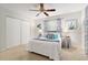 Bedroom featuring carpeted floor, ceiling fan, a bed with blue pillows, and matching decorations with large windows at 9940 Sw 101St Pl, Ocala, FL 34481