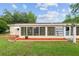 This is the rear exterior showing the Florida room with abundant windows and manicured lawn at 9940 Sw 101St Pl, Ocala, FL 34481