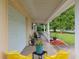Spacious covered front porch with chairs, plants, and easy access to the garage, perfect for relaxing at 9940 Sw 101St Pl, Ocala, FL 34481