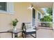 Cozy front porch with comfortable seating, plants, and a view of the landscaped yard at 9940 Sw 101St Pl, Ocala, FL 34481