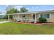 Charming single-story home featuring a manicured lawn and a quaint, fenced-in front porch area at 9940 Sw 101St Pl, Ocala, FL 34481