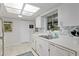 Well-lit kitchen with a view of the sink, featuring white cabinetry and appliances at 9940 Sw 101St Pl, Ocala, FL 34481
