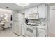 Bright kitchen featuring white appliances, cabinets, and blue tile backsplash at 9940 Sw 101St Pl, Ocala, FL 34481