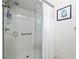 Glass-enclosed shower featuring a showerhead, safety bar, soap and shampoo storage, and a hanging curtain at 9940 Sw 101St Pl, Ocala, FL 34481