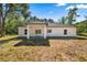 View of the home's back exterior with a covered patio and windows overlooking the yard at 14540 Se 33Rd Ter, Summerfield, FL 34491