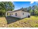 Backyard view showcasing the rear exterior of the house with a lawn and a covered patio at 14540 Se 33Rd Ter, Summerfield, FL 34491
