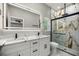 Modern bathroom featuring double sinks, marble countertops, a glass-enclosed shower with rain shower head, and stylish fixtures at 14540 Se 33Rd Ter, Summerfield, FL 34491
