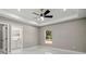 Bedroom with tray ceiling, ceiling fan, bright window, and access to en suite bathroom and walk-in closet at 14540 Se 33Rd Ter, Summerfield, FL 34491