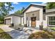 Inviting home featuring a covered front porch, stylish front door and a manicured walkway at 14540 Se 33Rd Ter, Summerfield, FL 34491
