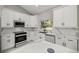 A modern kitchen with white cabinets, a black and white marble countertop, and stainless steel appliances at 14540 Se 33Rd Ter, Summerfield, FL 34491