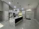 Modern kitchen features white cabinets, a large island with quartz countertops, and stainless steel appliances at 14540 Se 33Rd Ter, Summerfield, FL 34491