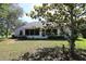 Back view of a single story home featuring a screened in porch and lush green backyard at 15324 Sw 28Th Avenue Rd, Ocala, FL 34473
