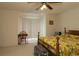 Comfortable bedroom featuring a wood frame bed, desk and a ceiling fan with lights at 15324 Sw 28Th Avenue Rd, Ocala, FL 34473