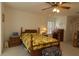 Spacious bedroom with floral bedding, wooden furniture, and a vintage television at 15324 Sw 28Th Avenue Rd, Ocala, FL 34473