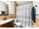 Bathroom featuring earth tone, tiled walls, a sink, toilet and shower with a curtain at 16220 Sw 19Th Avenue Rd, Ocala, FL 34473