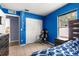 Bedroom with blue accent wall, tiled flooring, closet, window and gaming chair at 16220 Sw 19Th Avenue Rd, Ocala, FL 34473
