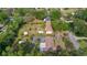 Wide-angle aerial shot of a house amid lush greenery with detached sheds enhancing the landscape at 2032 Se 12Th St, Ocala, FL 34471