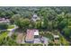 Expansive aerial view of a home featuring lush greenery, a circular driveway, and complementary backyard sheds at 2032 Se 12Th St, Ocala, FL 34471