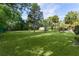 Expansive backyard with lush lawn, mature trees, and a detached shed in a serene setting at 2032 Se 12Th St, Ocala, FL 34471
