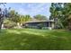 Wide shot of a lush backyard featuring a house, screened lanai, shed and gazebo at 2032 Se 12Th St, Ocala, FL 34471