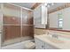 Functional bathroom featuring a shower with sliding glass doors, white vanity, and neutral tile accents at 2032 Se 12Th St, Ocala, FL 34471
