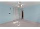 Bright bedroom featuring light blue walls, neutral carpet, and a closet with bi-fold doors at 2032 Se 12Th St, Ocala, FL 34471