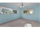 Bright bedroom featuring light blue walls, neutral carpet, and ample natural light from the windows at 2032 Se 12Th St, Ocala, FL 34471